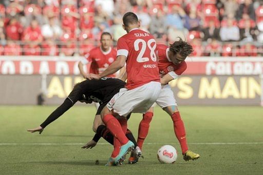 FC Augsburg's midfielder Marcel de Jong (L) clashes with Mainz' striker Adam Szalai (C) and midfielder Nicolai Mueller
